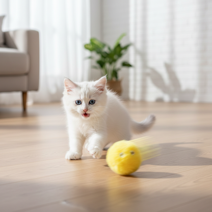 Interactive Plush Catnip Ball – kitten batting yellow plush ball across wooden floor with motion blur