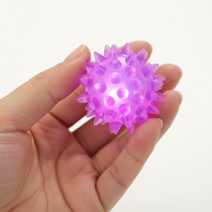 LED Pet Ball Toy – close-up of rubber ball glowing purple-pink in hand